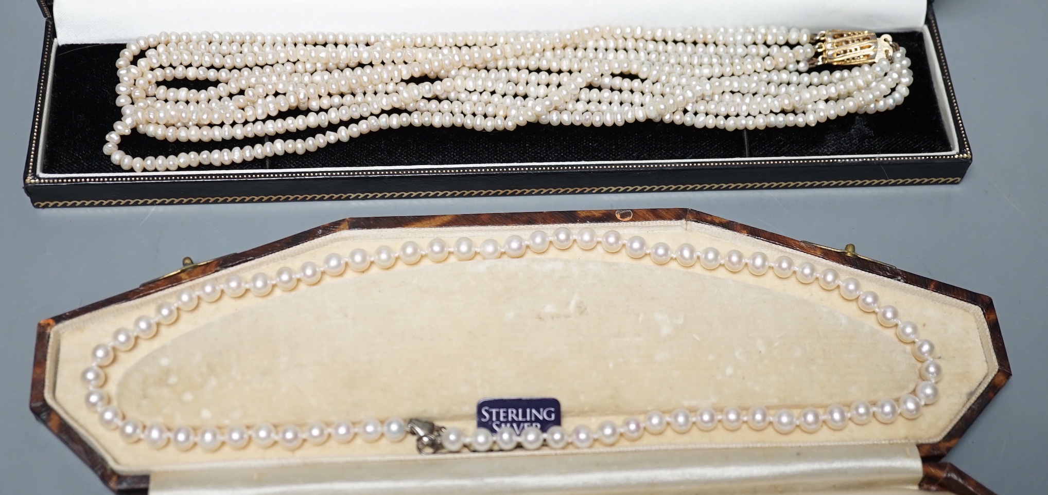 A single strand cultured pearl necklace, with sterling clasp, 44.5cm and a quadruple strand baroque seed pearl necklace, with gilt metal clasp, 42cm.